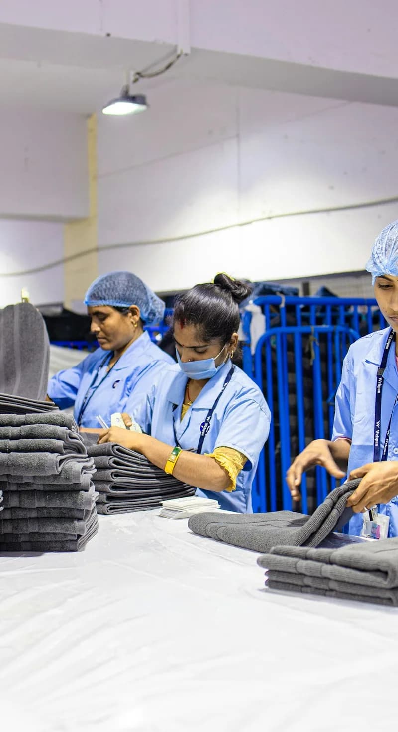 Staff folding freshly laundered towels at a work table