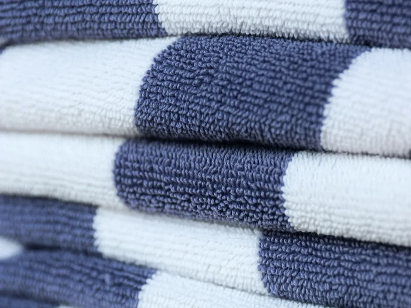 Neatly folded navy and white towels stacked in a pile