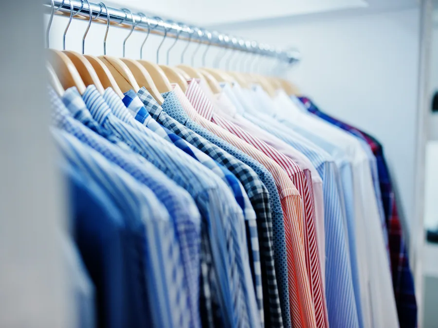 Pressed shirts hanging individually on a rail